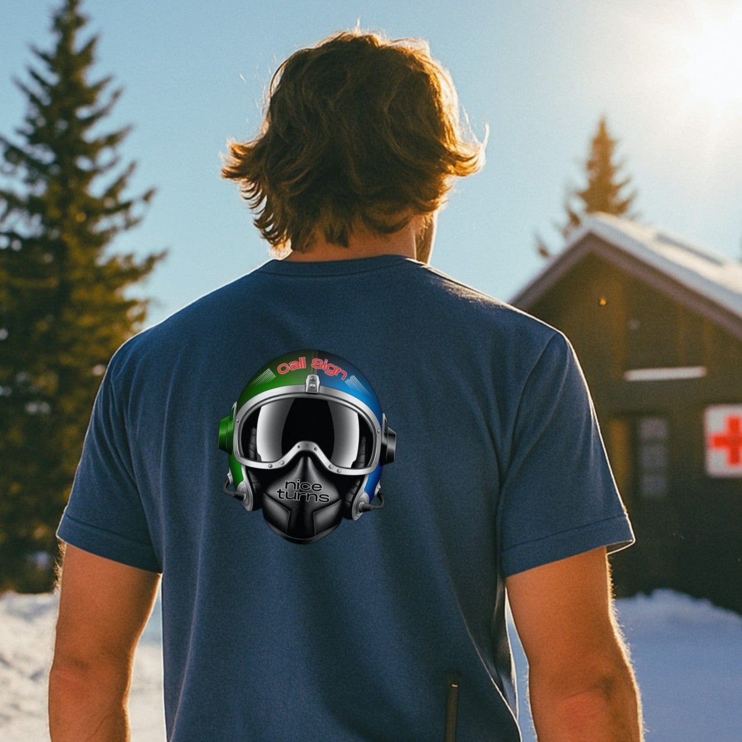 Indigo t-shirt with nice turns Call Sign helmet design on the back, worn outside a ski patrol hut in late afternoon sun.
