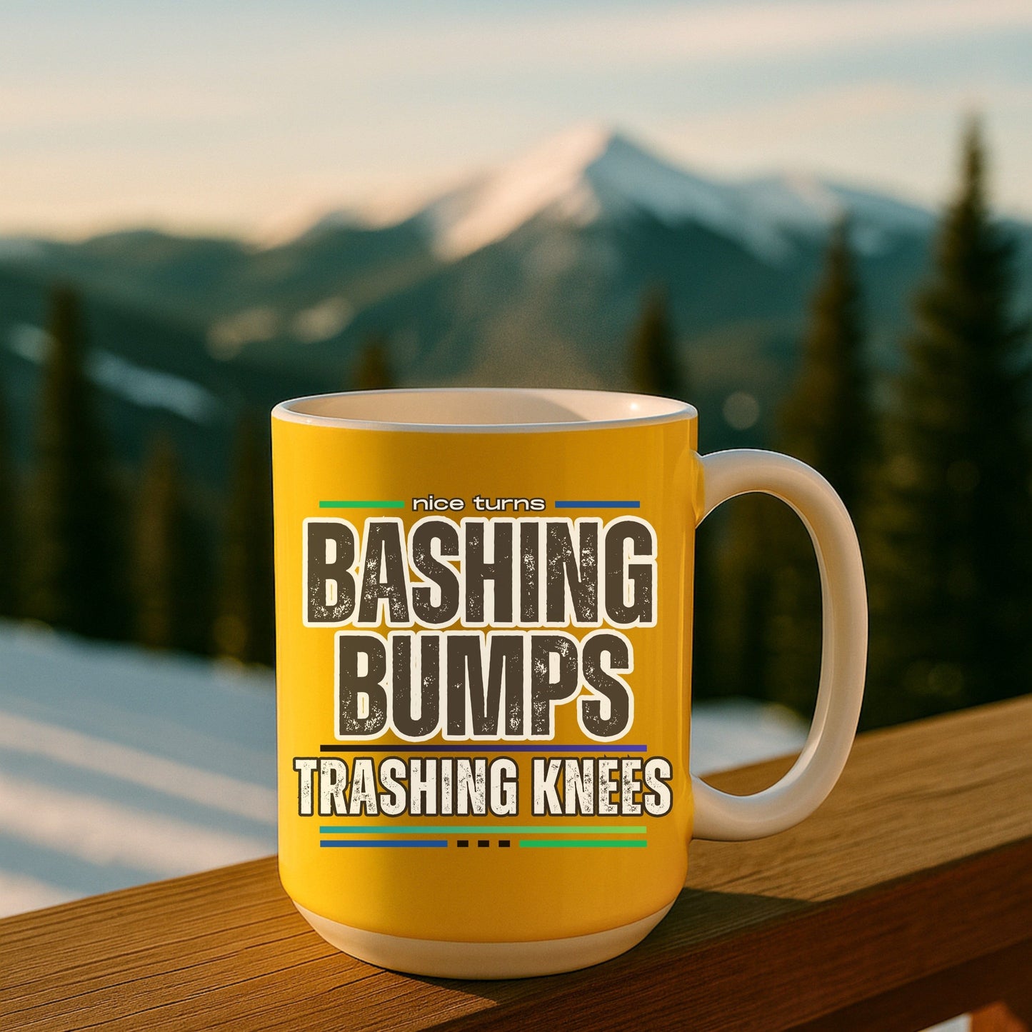 Bashing Bumps 15 oz coffee mug, yellow background, on ski lodge deck at sunrise; full “Trashing Knees” wraparound graphic in clear view.