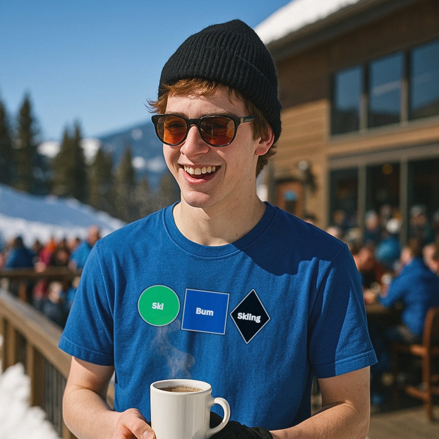 Young skier in royal blue No Lift Left Behind shirt and sunglasses holding coffee, standing on ski lodge deck with snowy slopes and crowd behind.