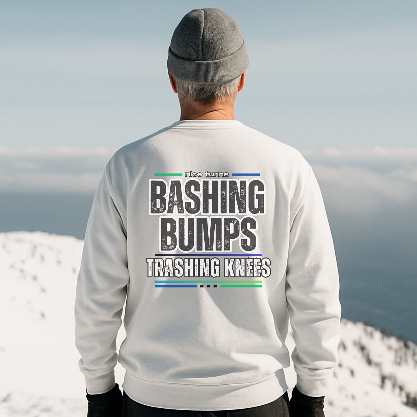 Bashing Bumps Sweatshirt, white, back lifestyle view on snowy ridgeline; bold “Trashing Knees” ski graphic across shoulders; relaxed fleece fit.